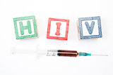 Wood blocks in green and red spelling out hiv with syringe