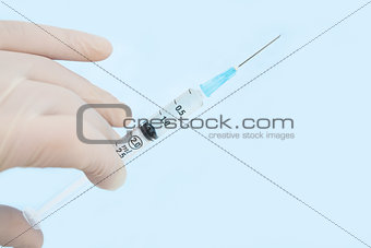 Gloved hand holding syringe