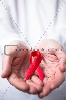 Man holding red aids ribbon