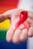 Man holding red aids awareness ribbon