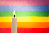 Candle against rainbow flag