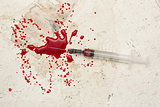 Syringe lying on floor with blood