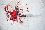 Three syringes in pool of blood