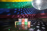 Block spelling gay pride under light of disco ball