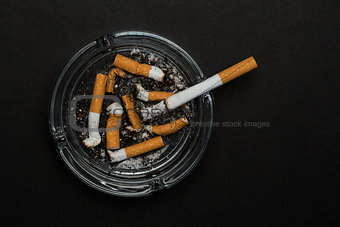 Burning cigarette left in ashtray