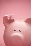 Piggy bank wearing pink ribbon