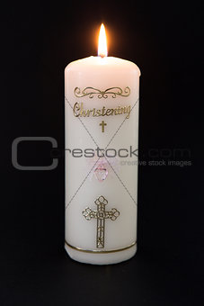 Lit white christening candle with pink detail
