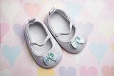 Baby blue booties on heart pattern background
