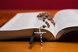 Rosary beads resting on open bible