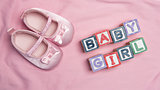 Baby girl spelled out in blocks with pink booties