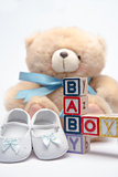 Blocks spelling baby boy with teddy and baby shoes