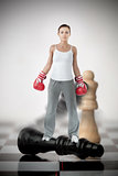 Female boxer standing on black chess piece