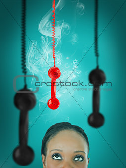 Woman looking up at hanging telephone receiver
