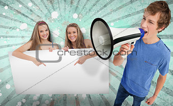 Pretty girls pointing to copy space with young man shouting through megaphone