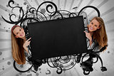 Girls pointing to black copy space with artistic swirl frame