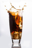 Ice cube falling into a glass of soda