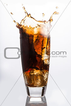 Ice cube falling into a glass of soda