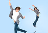 Two of the same teenage boy jumping for joy