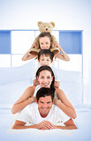 Smiling family leaning on each others shoulders in bed