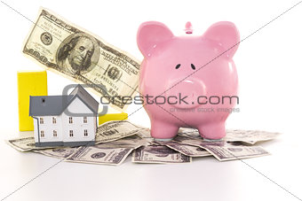 Pink piggy bank beside miniature house and graph