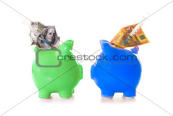 Dollar and euro notes and syringes sticking out of piggy banks