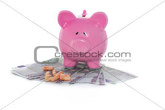 Piggy bank on pile of dollars with tablets