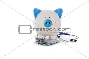 Piggy bank sitting on euro notes with stethoscope