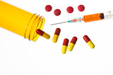 Jar of medicine spilling tablets with syringe