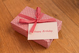 Pink wrapped present with birthday card greeting