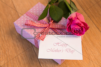 Pink wrapped present with happy mothers day card and pink rose