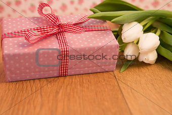 Pink wrapped present with bunch of white tulips