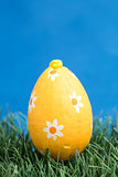 Orange wrapped easter egg on grass