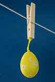 Yellow easter egg hanging from line