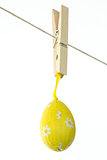 Yellow easter egg hanging from a line