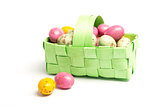 Colourful little easter eggs in a green wicker basket