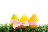 Three easter eggs wrapped in pink ribbon with a bow