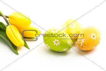 Three easter eggs with yellow tulips