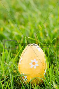 Orange easter egg sitting in the grass