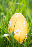 Orange easter egg nestled in the grass