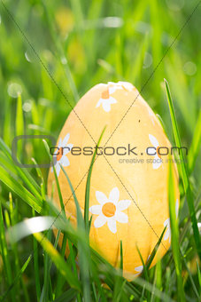 Orange easter egg nestled in the grass