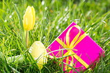 Pink gift box with easter egg and yellow tulip