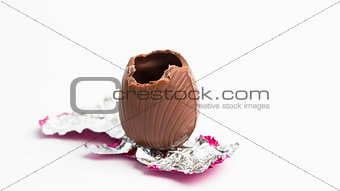 Easter egg unwrapped in pink foil with bite taken out