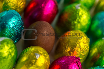 Colourful easter eggs with one unwrapped