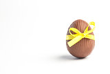 Chocolate easter egg in a yellow ribbon
