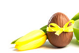 Chocolate easter egg in a yellow ribbon with tulip