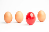 Four eggs in a row with one red one standing out
