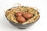 Chocolate easter eggs in straw in bowl