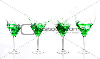 Serial arrangement of green liquid splashing in cocktail glass