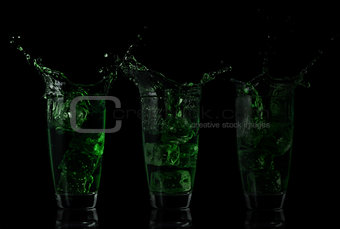 Serial arrangement of green liquid splashing in glass