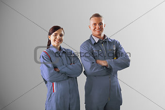 Two mechanics standing on grey background